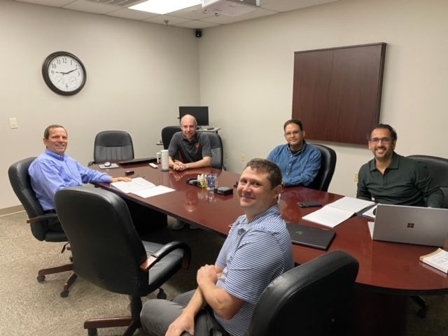 Five men sitting around a conference table