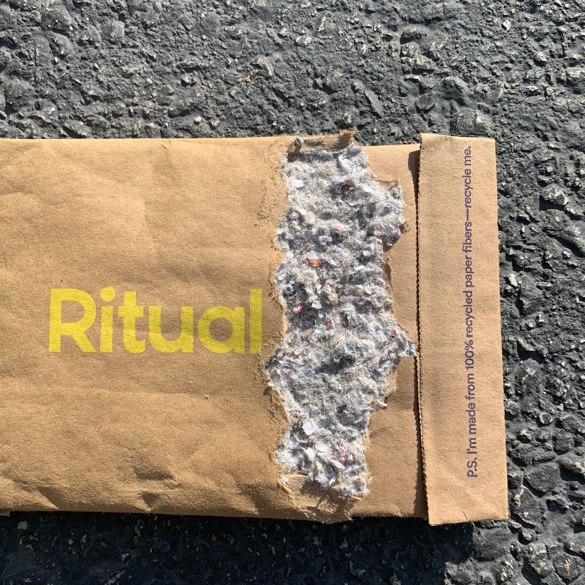 Ritual packaging mailer with a tear that shows recycled paper fibers inside.