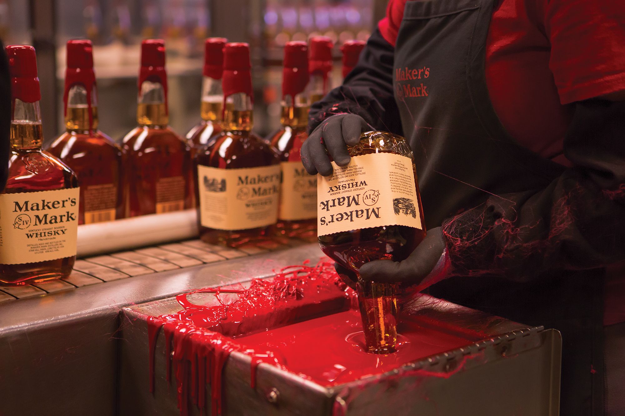 Hand-dipping Maker's Mark bottles into red wax