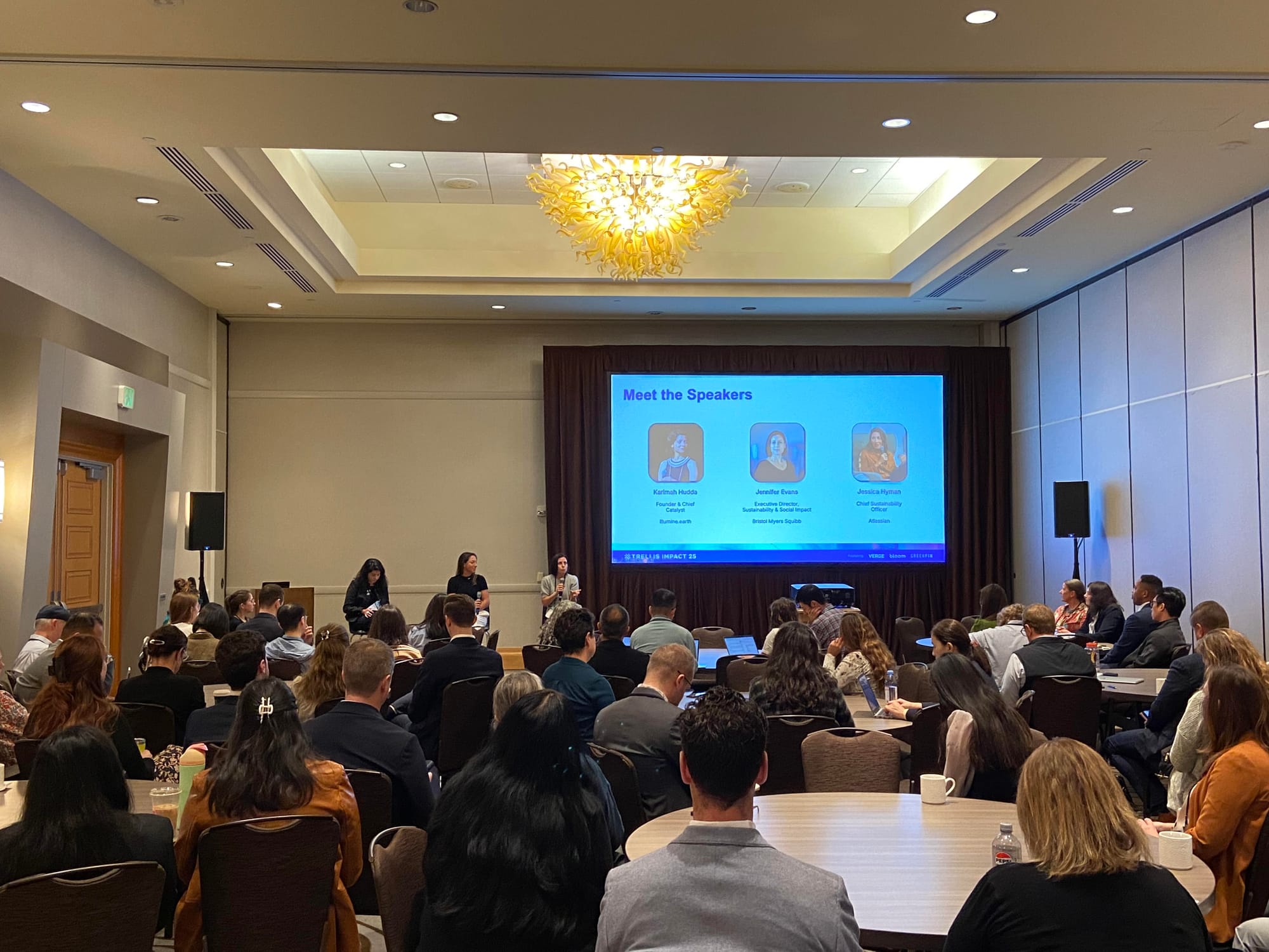 Three people speaking at a conference