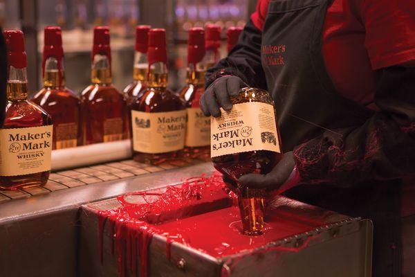 Hand-dipping Maker's Mark bottles into red wax
